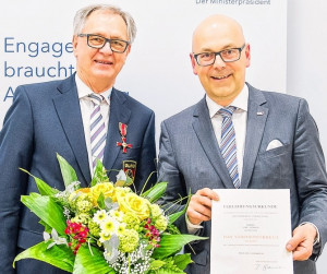 Uwe Lensch (links) engagiert sich seit 60 Jahren in der DLRG. Ministerpräsident Torsten Albig übergab das vom Bundespräsidenten verliehene Verdienstkreuz und die Urkunde. 
(c) Foto: Frank Peter